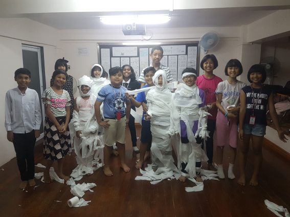 Children covered in toilet tissue dressed as mummies